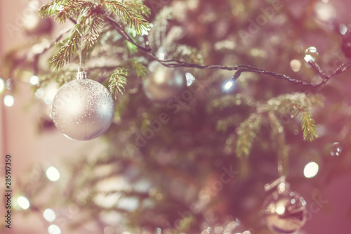 silver ball hanging on Christmas tree branch near garland