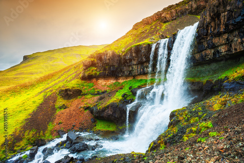 Beautiful waterfall in eastern Iceland at sunset. Summer landscape