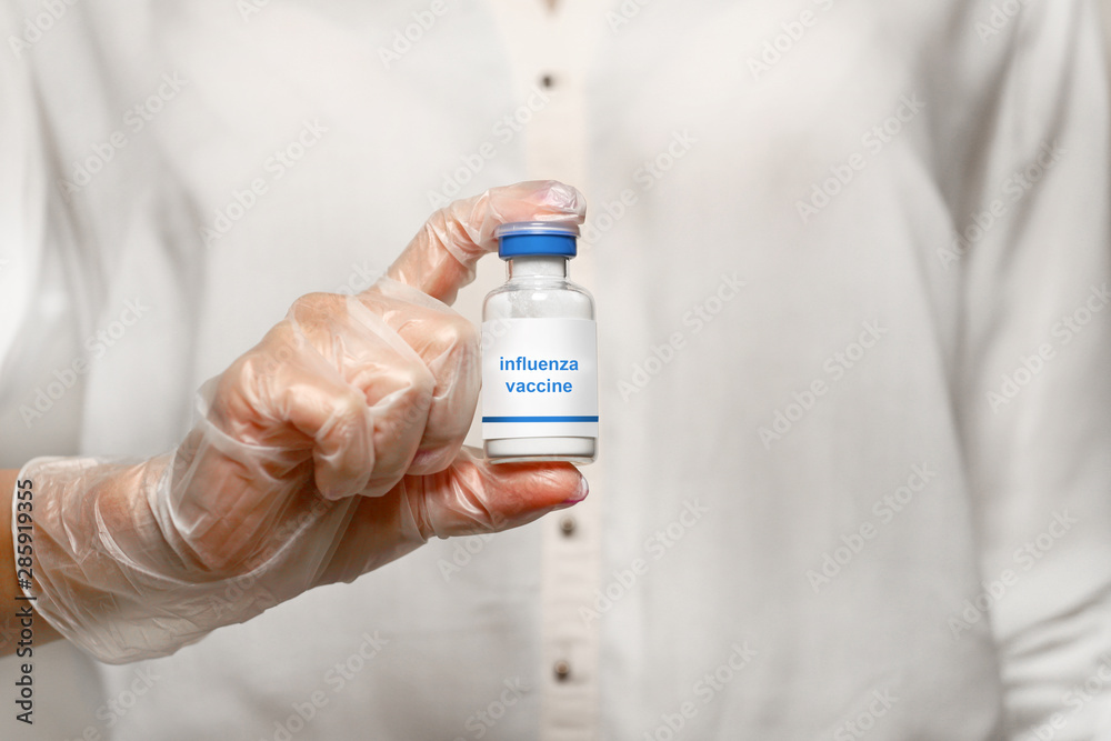 Fototapeta premium hand with bottle of medicine with flu vaccine 