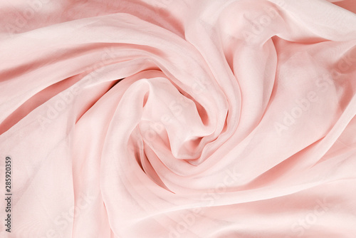 Soft smooth pink silk fabric background. Fabric texture.