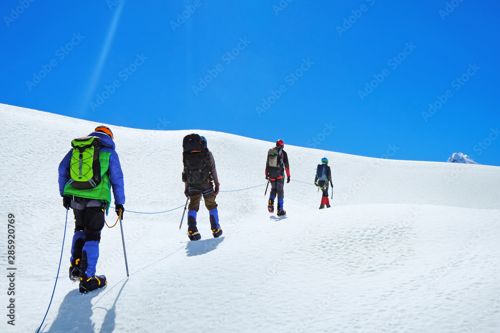 Hikers with backpacks reache the summit of mountain peak, Nepal