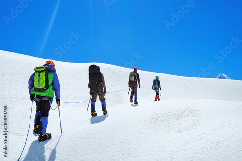 Hikers with backpacks reache the summit of mountain peak, Nepal