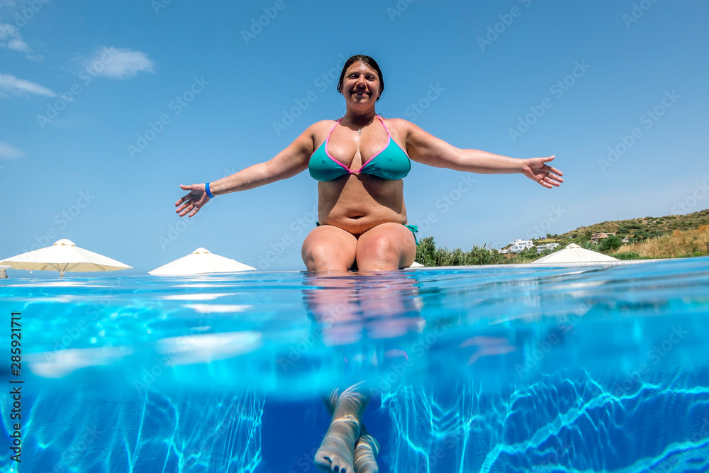 girl sunbathes on the edge of the pool in  sunny day