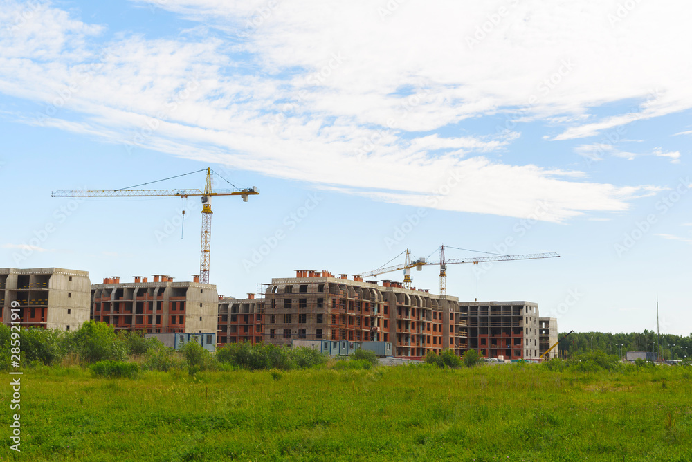 Crane and building under construction against blue sky