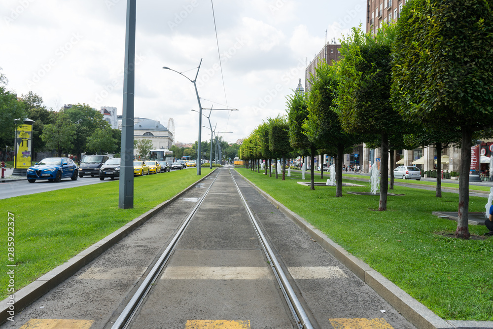 Budapest / Hungary - July 29 2019: Public transport in the city center of Budapest. Railroad in urban concept with trees and path.
