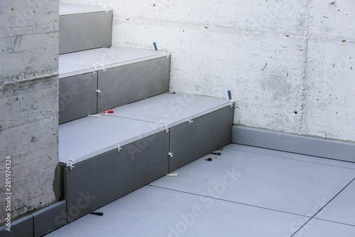 Fotografi Laying new tiles on a concrete steps outside of a building