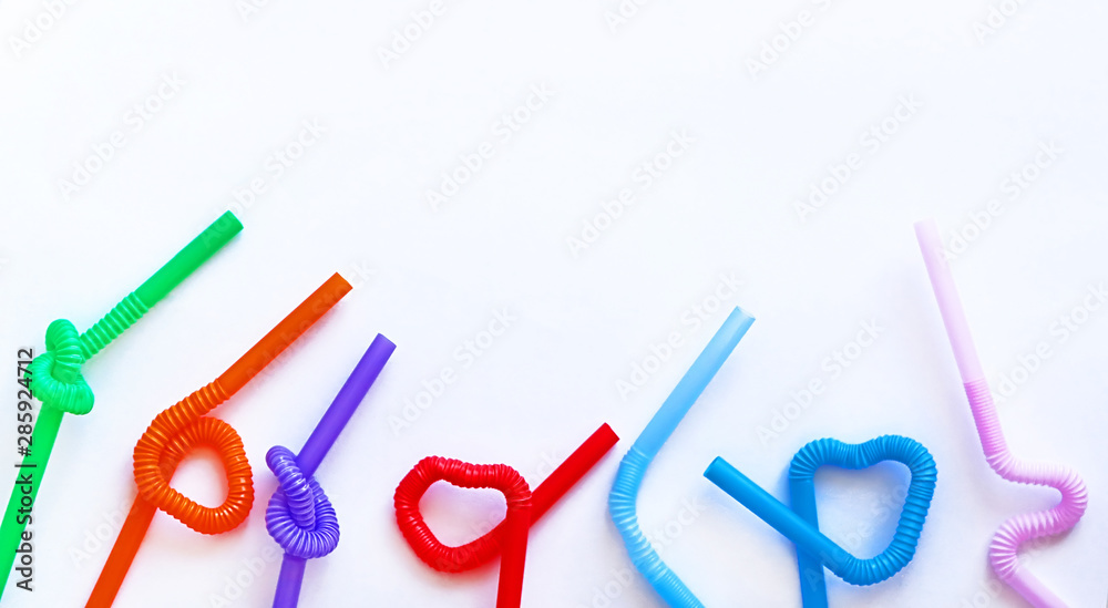Isolated colour plastic cocktail tubes with a flexible part, due to which they can be twisted into a knot or in a zigzag, or a heart shape, on a white background. Copy space. Eco concept. Banner Isolated colour plastic cocktail tubes with a flexible part, due to which they can be twisted into a knot or in a zigzag, or a heart shape, on a white background. Copy space. Eco concept. Banner