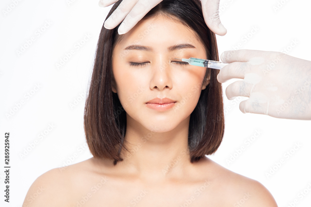 Asain young woman gets injection of botox in her lips. Woman in beauty salon. plastic surgery clinic.Beautiful woman gets botox injection in her face.