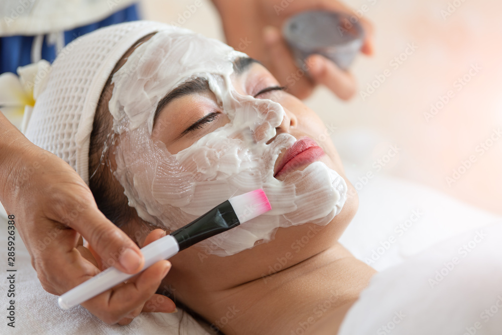 Beautiful Asian woman in mask on face in spa beauty salon, enjoying and relaxing time, skin care and healthcare concept