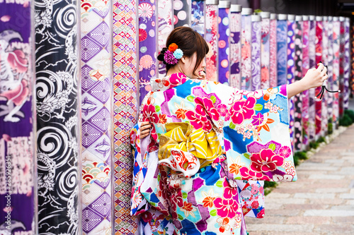 Fototapet Kimono women takes picture with Kimono Forest Different kimono fabrics in transp