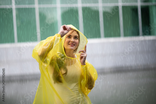 Women wearing yellow raincoat while raining in rainy season