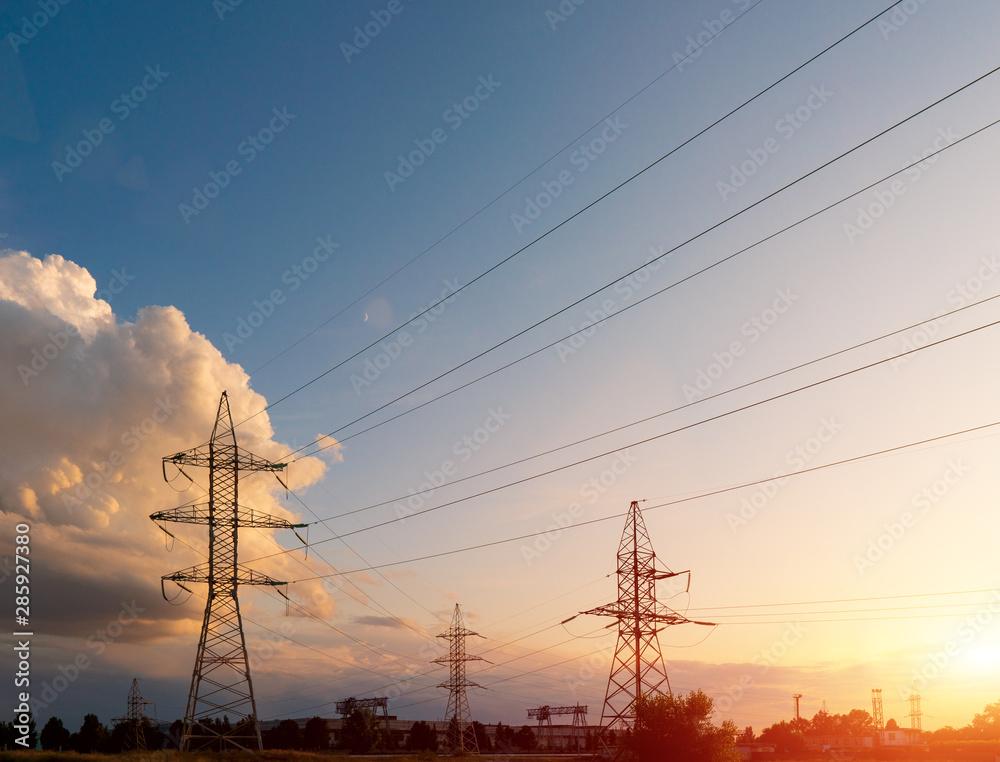 Power lines during a beautiful sunset. Transportation of electricity through the beautiful landscapes of the world.