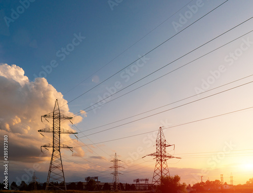 Power lines during a beautiful sunset. Transportation of electricity through the beautiful landscapes of the world.