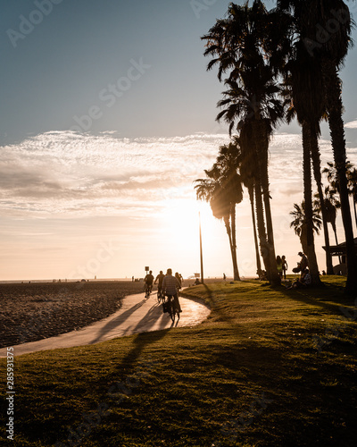 LOS ANGELES, USA - AUGUST 03 2019:  Cyclists at Venice Beach at sunset during the summer in Los Angeles USA