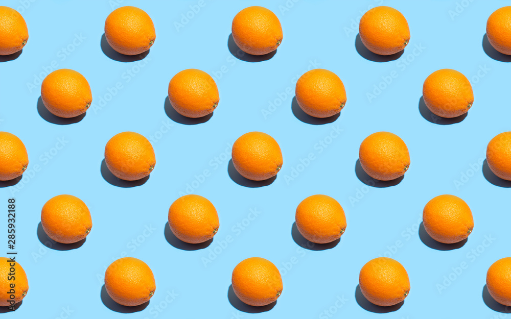 Fruit pattern of fresh orange on blue background. Top view. Summer concept. Collage. Healthy eating and dieting concept.