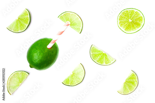 Flat lay composisition of juicy green lime slices, whole citrus with coral paper straw and haft fruit  isolated on white background. Healthy food concept