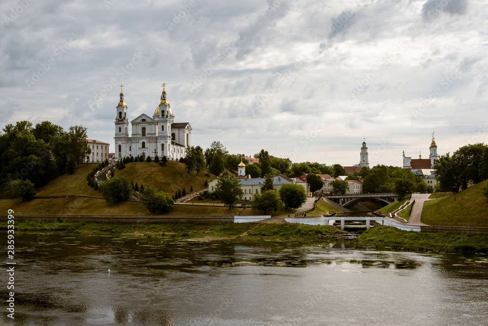 Landscape of Vitebsk, Belarus. Christian cathedral on mountain and river Dvina against the cloudy sky.