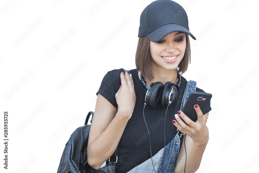 Woman on neutral background with gadgets. Modern youth. Young female listening to music and typing at smartphone. Woman on neutral background with gadgets. Modern youth. Young female listening to music and typing at smartphone.