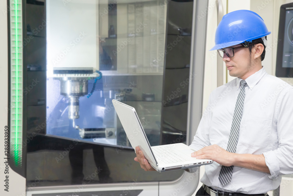 The engineer control the CNC milling machine by notebook. The machining center operation by engineer control processing. The engineer control the CNC milling machine by notebook. The machining center operation by engineer control processing.