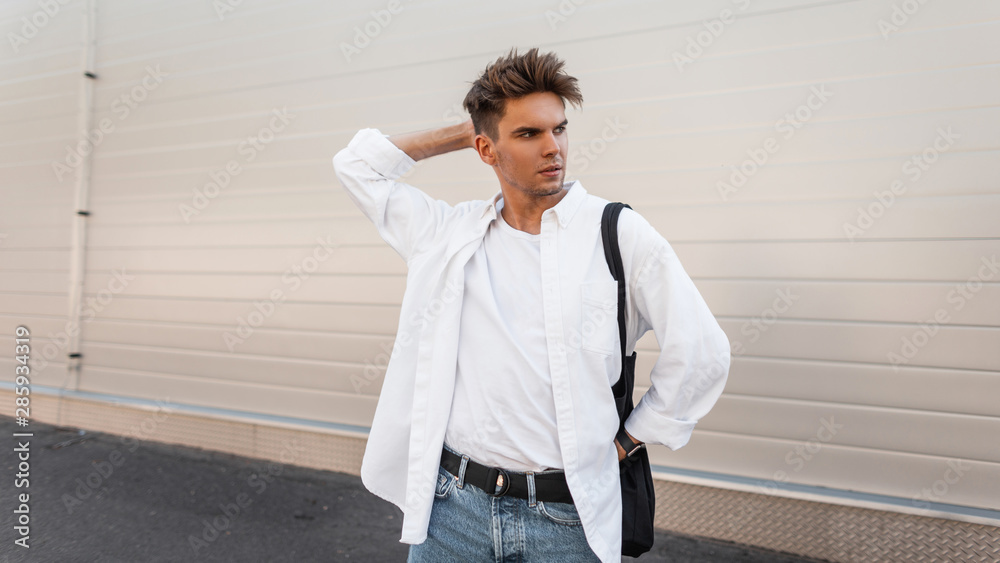 Young European Man with a Hairstyle in a Fashionable Shirt in Blue Jeans  with a Black Cloth Bag Poses in a Modern Building Stock Photo - Image of  fashionable, jeans: 196744386