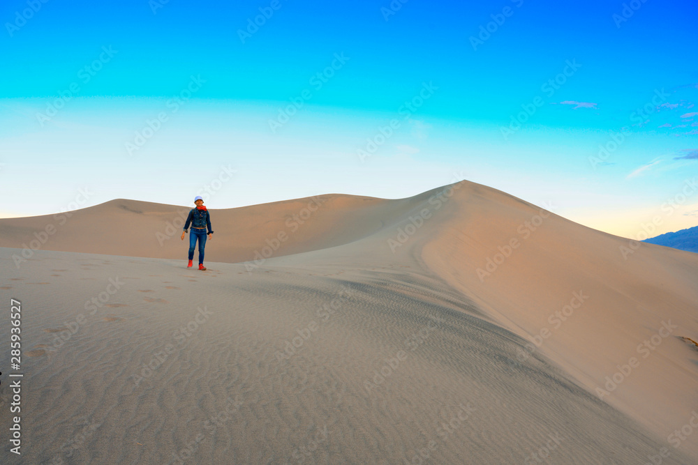 Woman walking on the top of sand dunes