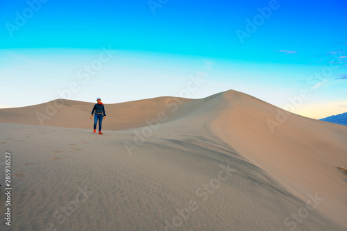 Woman walking on the top of sand dunes