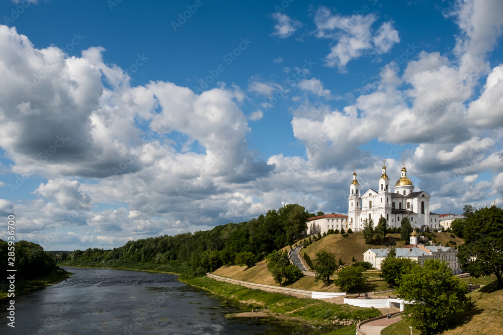 Landscape of Vitebsk, Belarus. Christian cathedral on mountain and river Dvina against the cloudy sky.