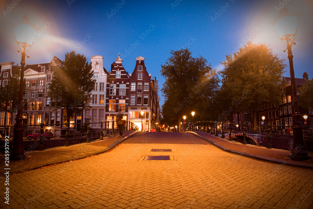 Street scene in Amsterdam at night with lights and architecture