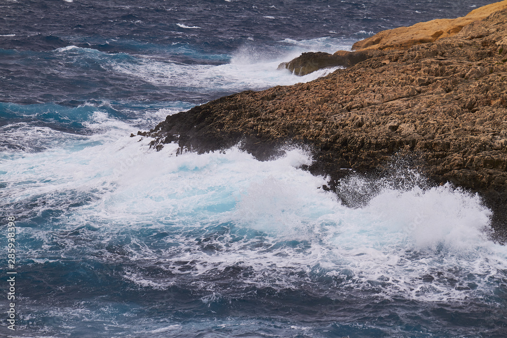 Huge waves crash on cloudy day. Kemmuna island