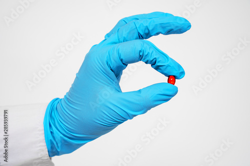 Hand and red pill close up. Treatment and health care. medicine for various diseases hospital concept.
