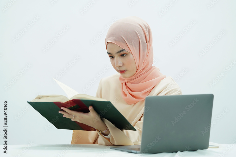 Asian muslim student is reading the book. Asian muslim student is reading the book.