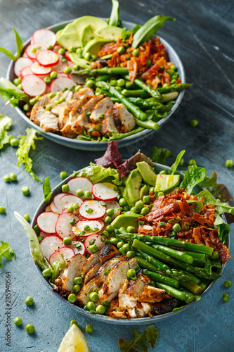 Cobb salad bowl with grilled chicken breast, asparagus, avocado, radishes and bacon
