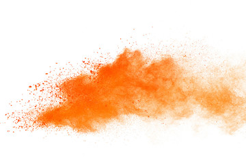 Abstract orange powder explosion. Closeup of orange dust particle splash isolated on white background