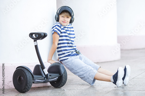 Cute little boy driving segway. Child skating on hyroboard. Boy driving hover. photo