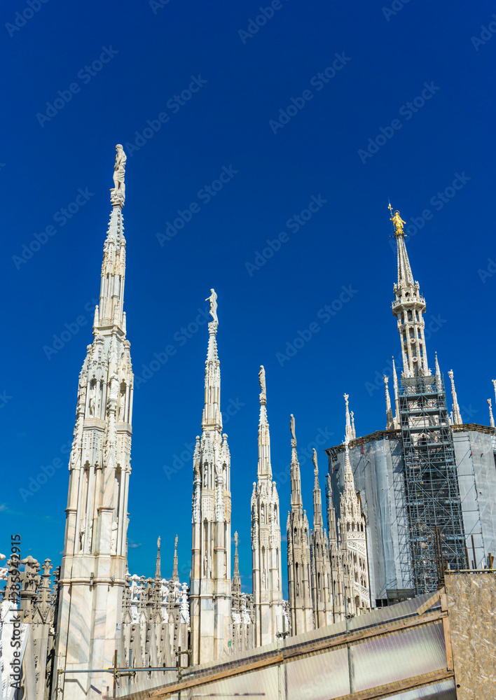 White marble statues on the roof of famous Cathedral Duomo di Milano in Italy White marble statues on the roof of famous Cathedral Duomo di Milano in Italy