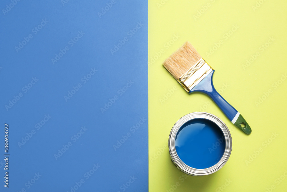 Open paint can, brush and space for text on color background, top view Open paint can, brush and space for text on color background, top view
