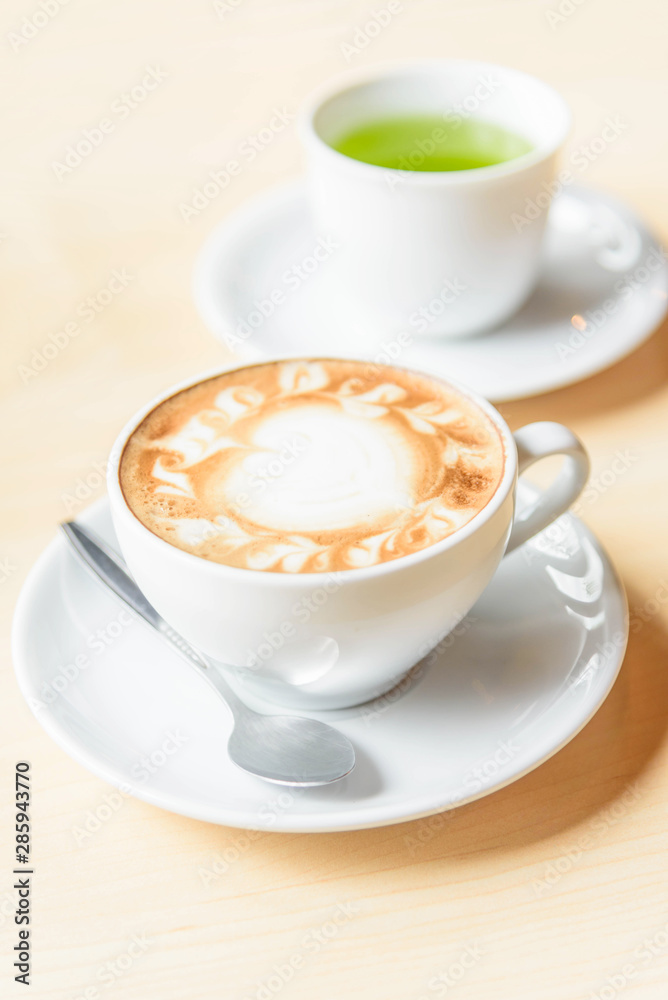hot cappuccino coffee with green tea on table hot cappuccino coffee with green tea on table