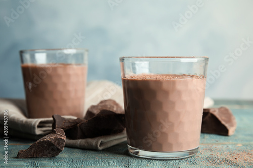Glasses with tasty chocolate milk on wooden table. Dairy drink