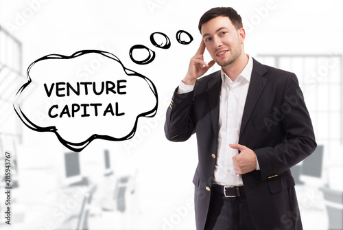 Business, technology, internet and network concept. The young businessman comes up with the keyword: Venture capital