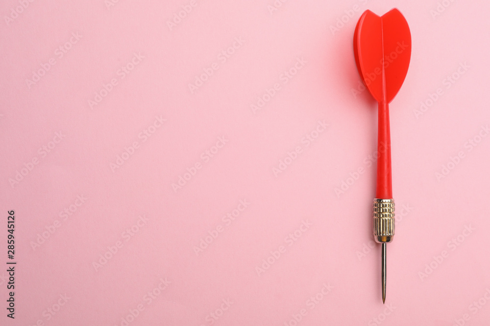 Red dart arrow on pink background, top view with space for text Red dart arrow on pink background, top view with space for text