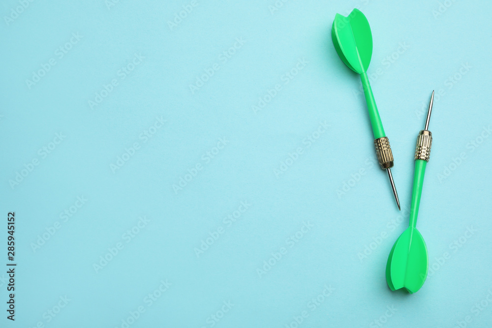 Green dart arrows on blue background, flat lay with space for text Green dart arrows on blue background, flat lay with space for text