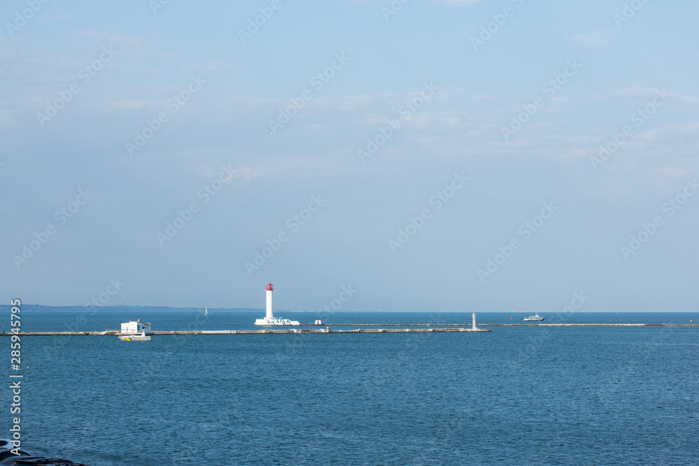 in the distance a lighthouse in Odessa cargo port on the Black Sea