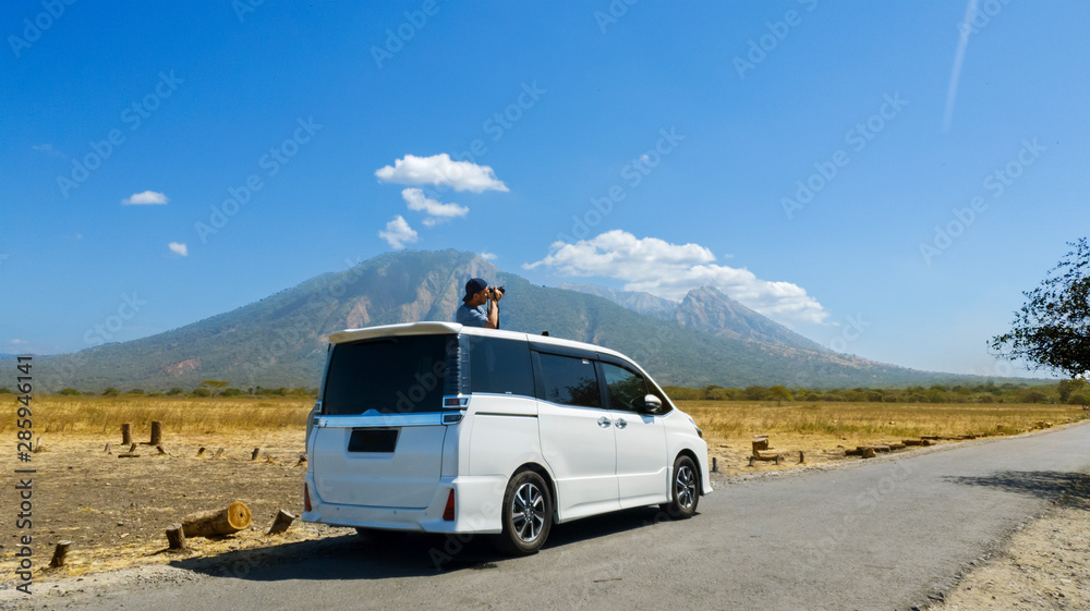 Obraz premium Photographer taking photos Baluran mountain view