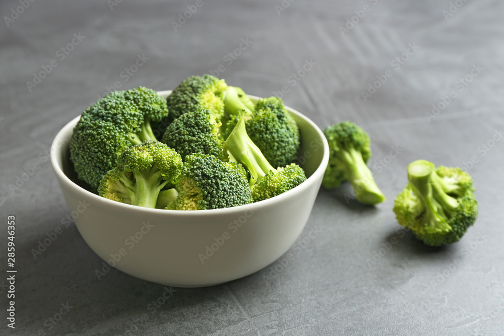 Bowl and fresh broccoli on grey table. Space for text Bowl and fresh broccoli on grey table. Space for text