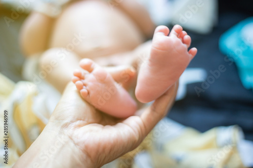 Baby feet holding by father hand massage selective focus