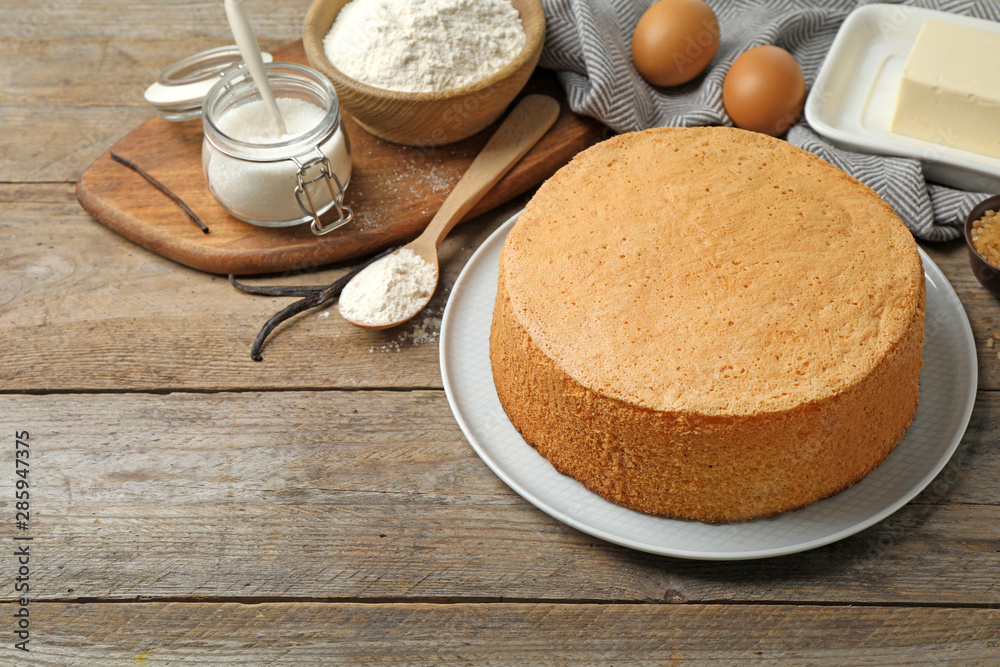 Delicious fresh homemade cake and ingredients on wooden table Delicious fresh homemade cake and ingredients on wooden table