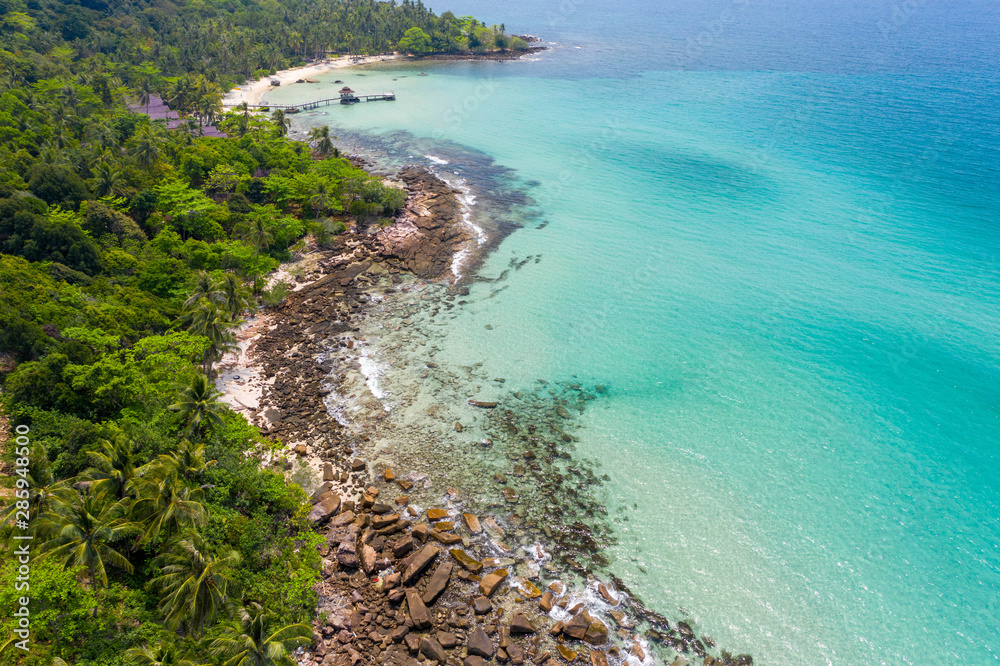 Aerial view of ocean waves, beach and rocky coastline and beautiful forestin island Koh Kood Thailand. Beautiful nature background.