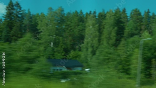 Travel with train in village. Windows seat. View from inside. Houses, trees, forest and fields. photo