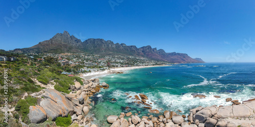 XXL aerial panoramic drone view of Camps Bay, an affluent suburb of Cape Town, South Africa. With its white beach, Camps Bay attracts many tourists. Twelve apostles mountain range in the background. photo