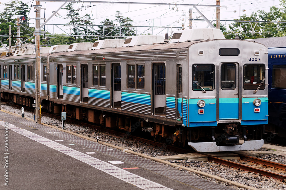 A stationary local train in Japan. The doors are left open for the maintenance or cleaning.